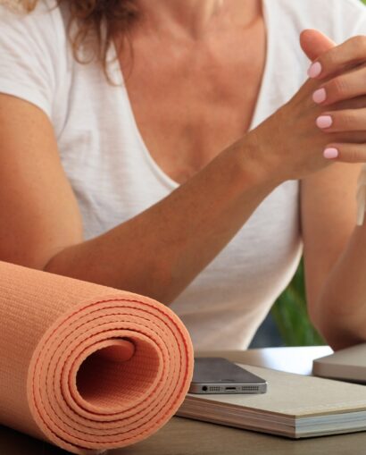 Woman beside a yoga mat checking her phone, illustrating a search-driven wellness case study.