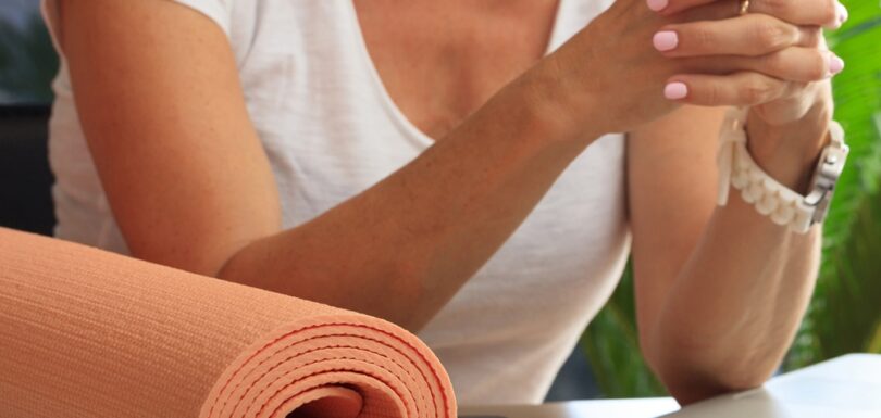 Woman beside a yoga mat checking her phone, illustrating a search-driven wellness case study.